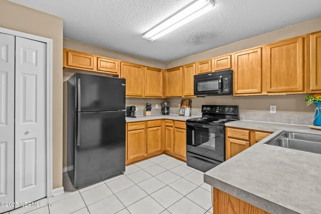 a kitchen with stainless steel appliances granite countertop a refrigerator stove and sink
