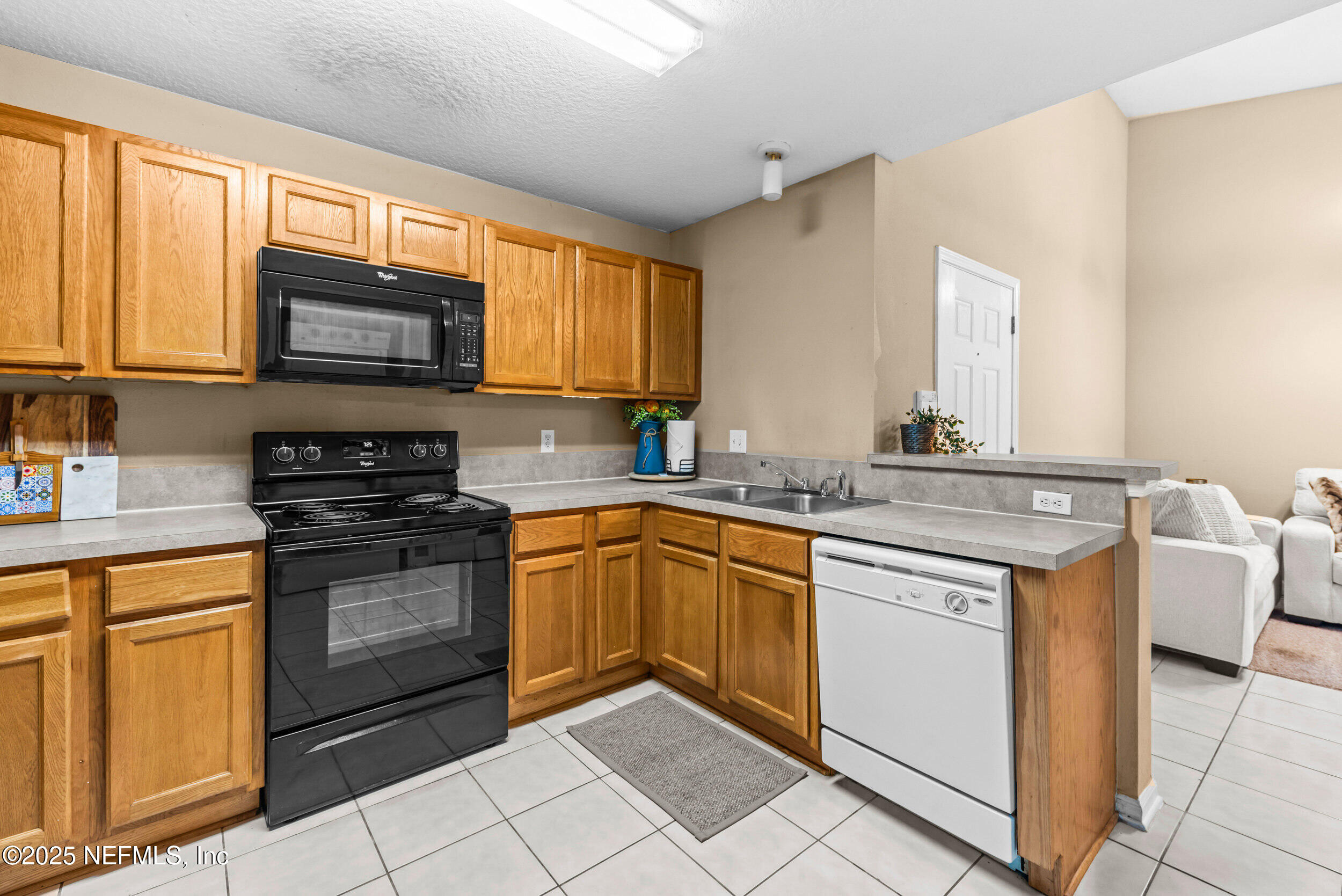 6094 Maggies Circle, Unit 109 Jacksonville, FL 32244 - Photo 12 of 30 a kitchen with stainless steel appliances granite countertop a stove a sink and a microwave
