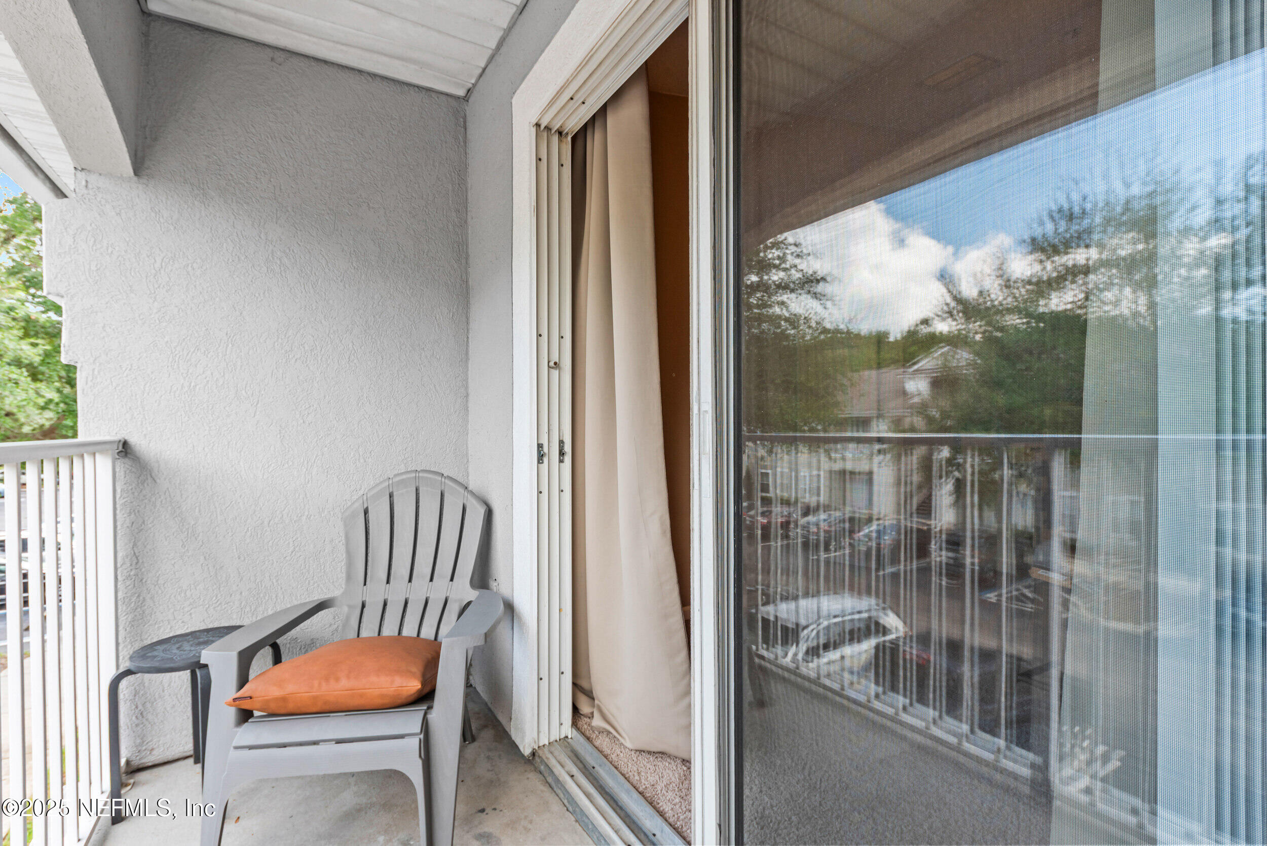 6094 Maggies Circle, Unit 109 Jacksonville, FL 32244 - Photo 23 of 30 a view of a porch with a door and wooden chairs