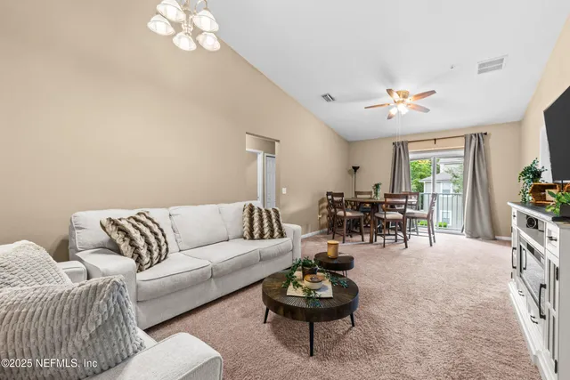 a living room with furniture a rug and a chandelier