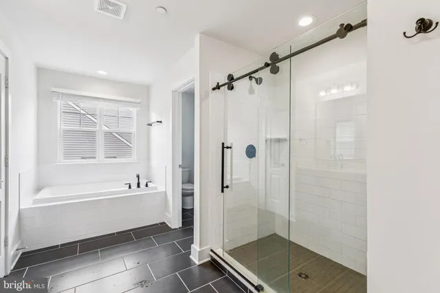 a bathroom with a bathtub shower and a sink
