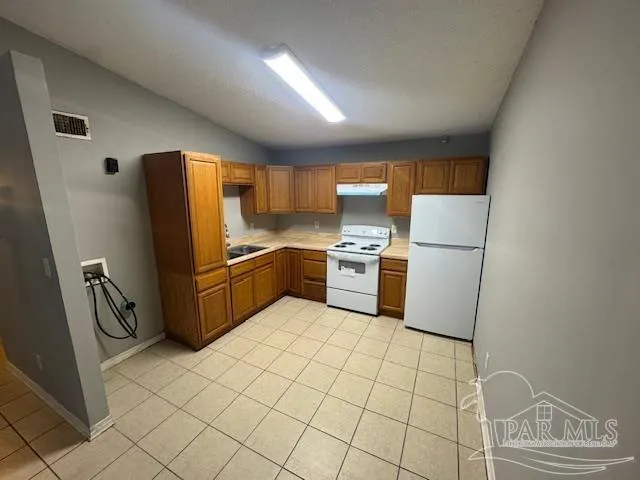 a kitchen with stainless steel appliances a refrigerator sink and cabinets