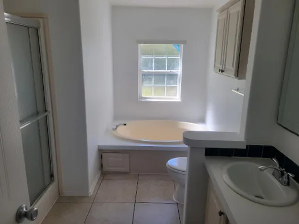 a bathroom with a sink a bathtub and a window