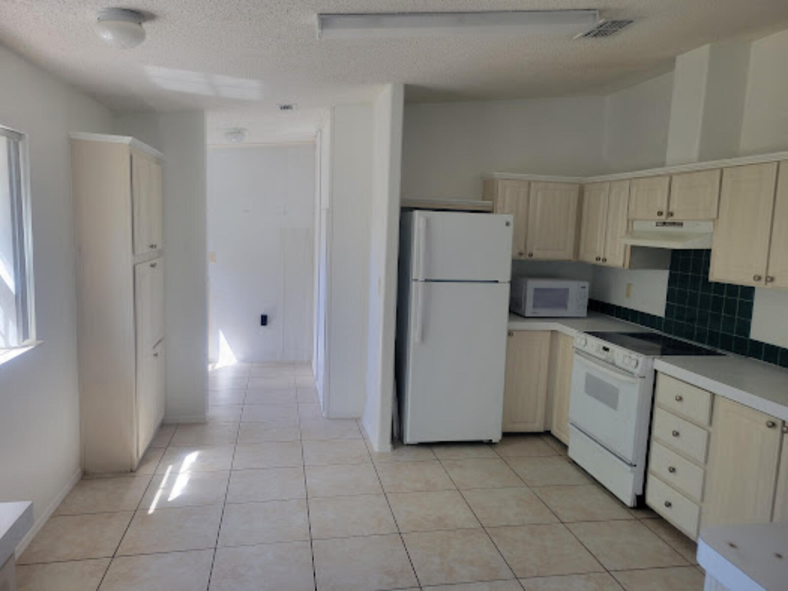31037 Ave D Big Pine Key, FL 33043 - Photo 6 of 20 a kitchen with a refrigerator a stove top oven and cabinets