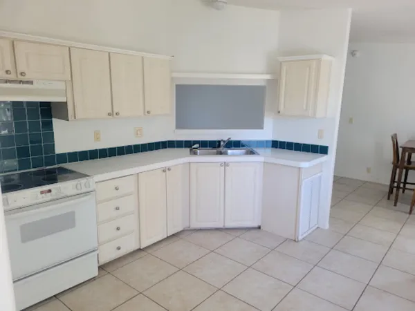 a kitchen with granite countertop white cabinets and white appliances