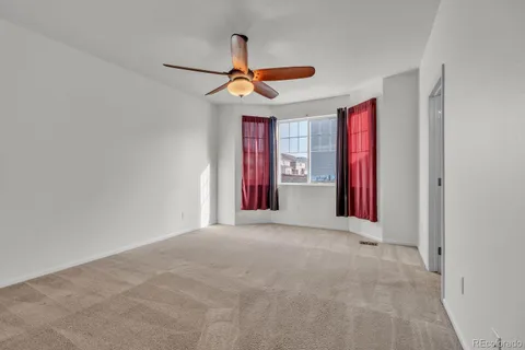 a view of a livingroom with a ceiling fan and window