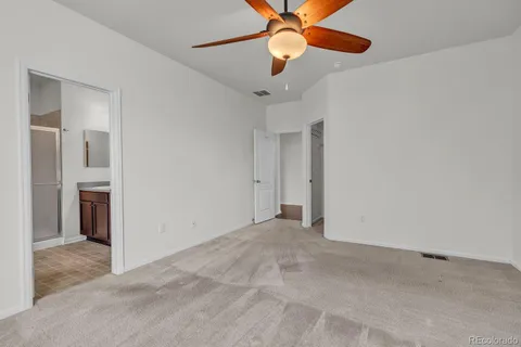 an empty room with closet and a chandelier fan