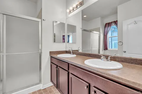 a bathroom with a granite countertop sink a mirror and a shower