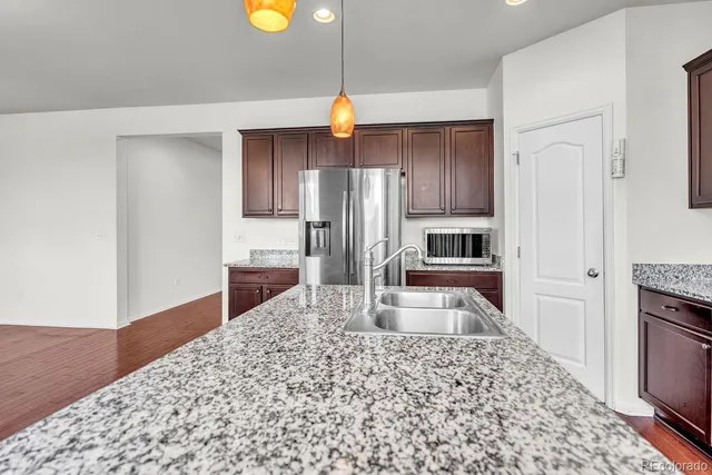 a kitchen with stainless steel appliances granite countertop a refrigerator and a stove top oven