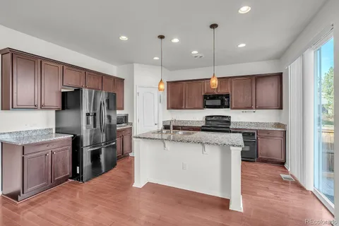 a kitchen with kitchen island granite countertop wooden cabinets and stainless steel appliances