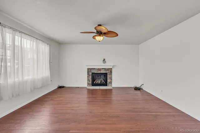 an empty room with windows and fireplace
