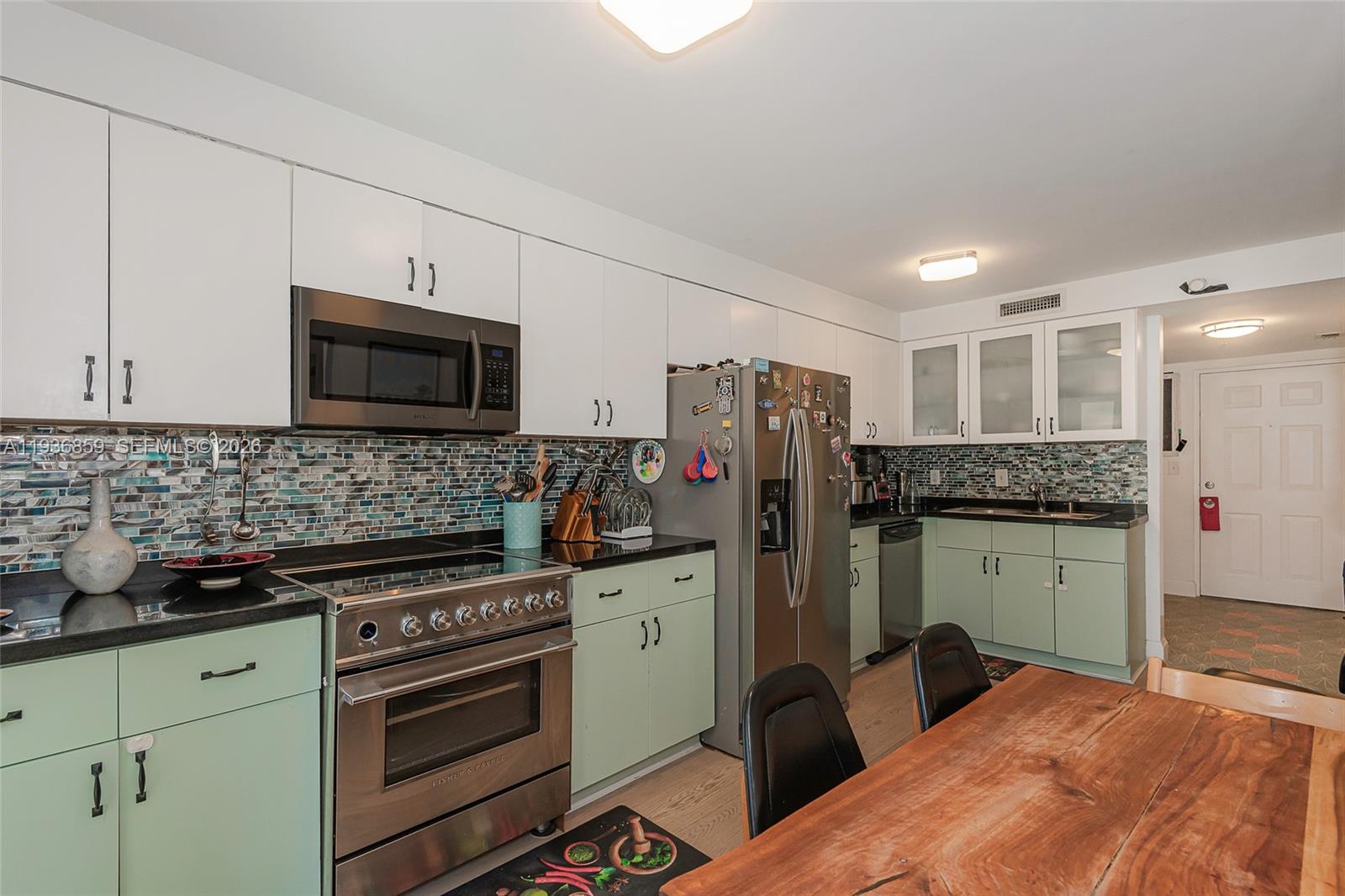 1005 8th Street, Unit 204 Miami Beach, FL 33139 - Photo 11 of 33 a kitchen with granite countertop a refrigerator stove and microwave