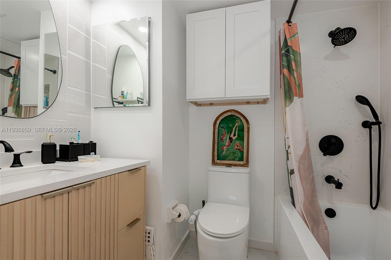 1005 8th Street, Unit 204 Miami Beach, FL 33139 - Photo 16 of 33 a bathroom with a sink a toilet and a mirror