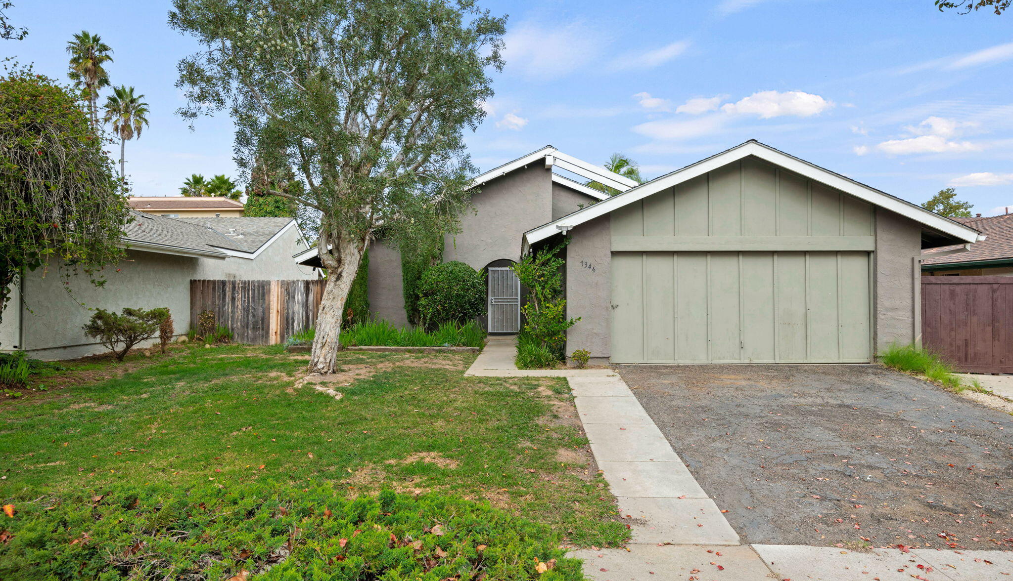 a view of a house with a yard and large tree