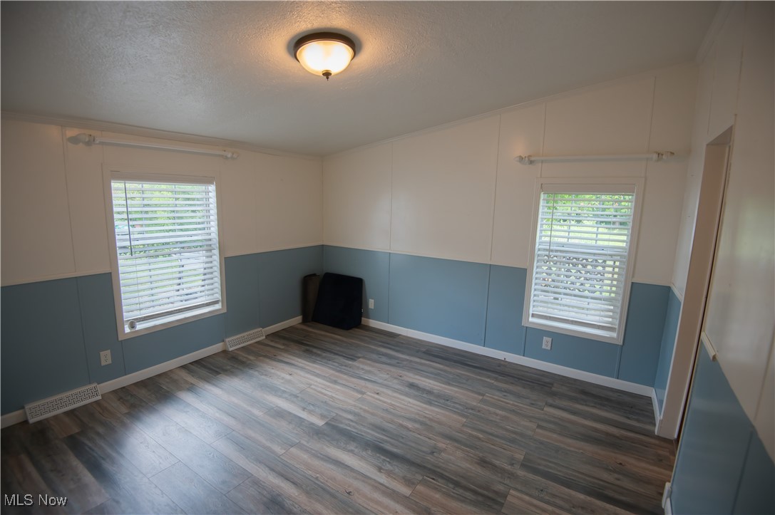 4594 Center Road Andover, OH 44003 - Photo 15 of 39 Spare room with dark wood-type flooring, a textured ceiling, and crown molding