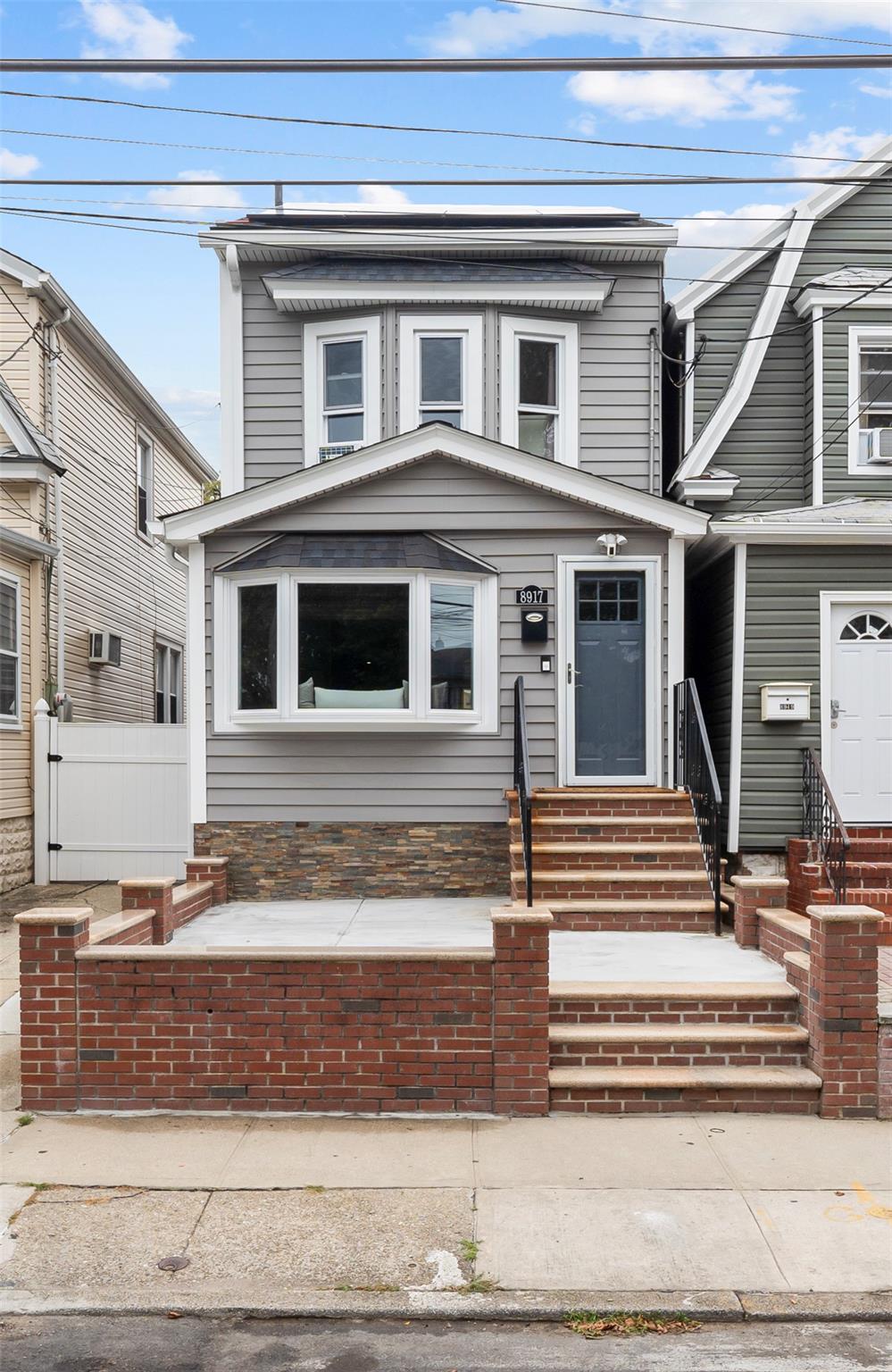 89-17 91st Street Queens, NY 11421 - Photo 1 of 1 View of front of house with entry steps and fence