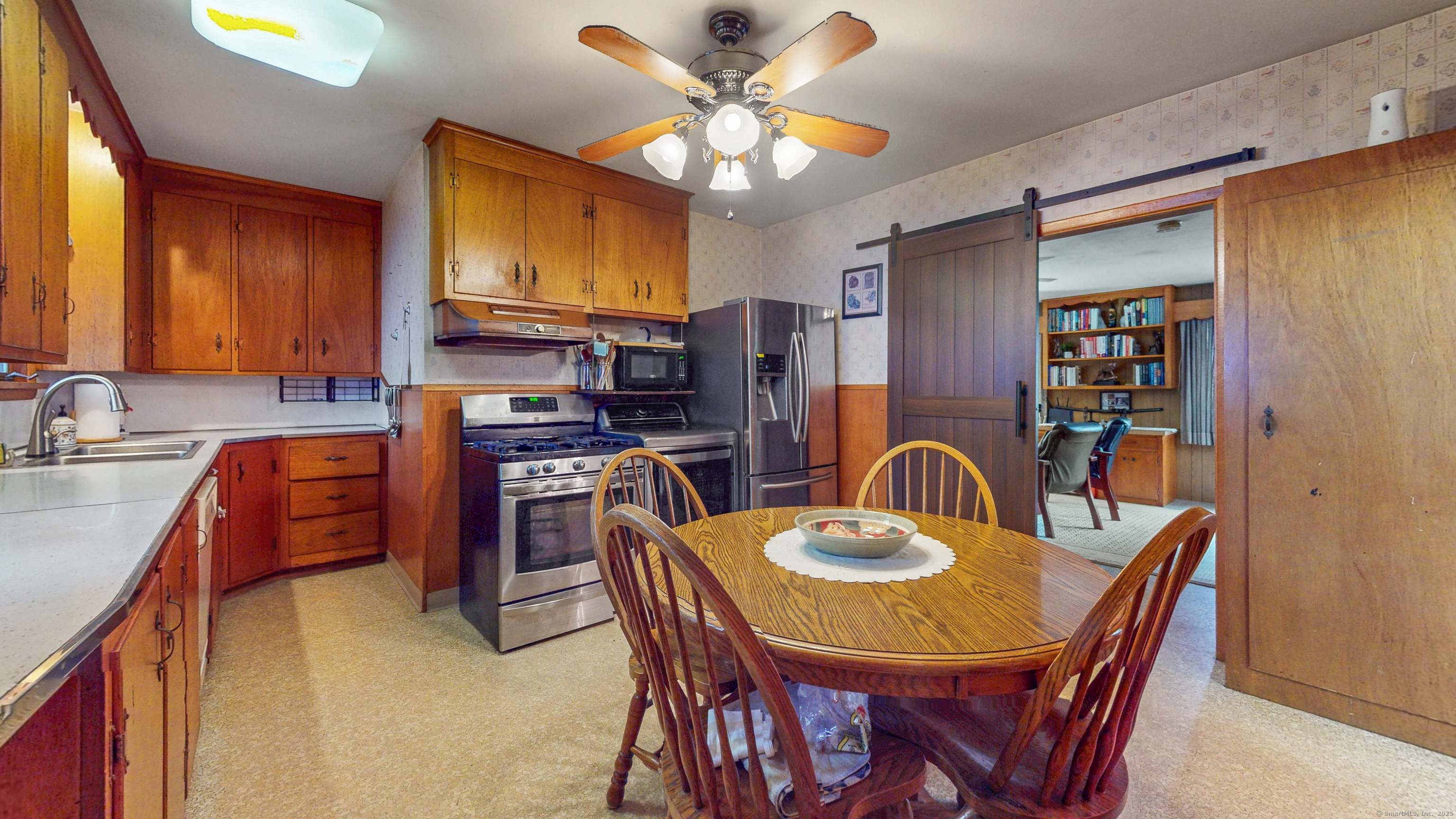 59 Elm Street Windsor Locks, CT 06096 - Photo 13 of 38 a kitchen with stainless steel appliances granite countertop a sink a stove a kitchen island with chairs and wooden floor