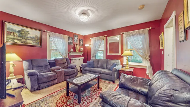 a living room with furniture a large window and a chandelier
