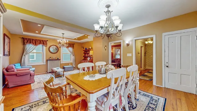 a view of a dining room with furniture wooden floor and chandelier