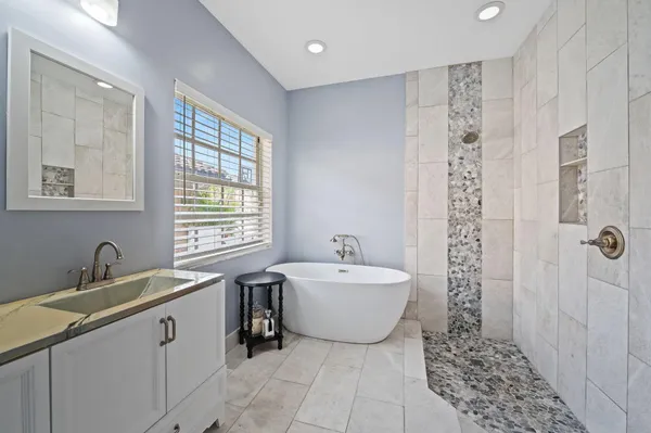 a spacious bathroom with a double vanity sink a mirror and a bathtub