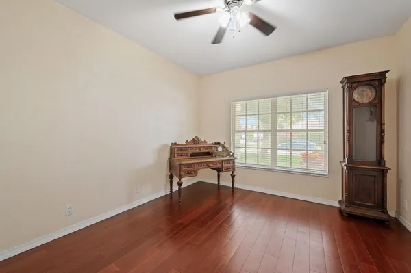 a view of an empty room with a window and wooden floor