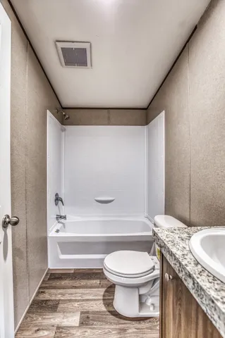 a bathroom with a granite countertop toilet sink and shower