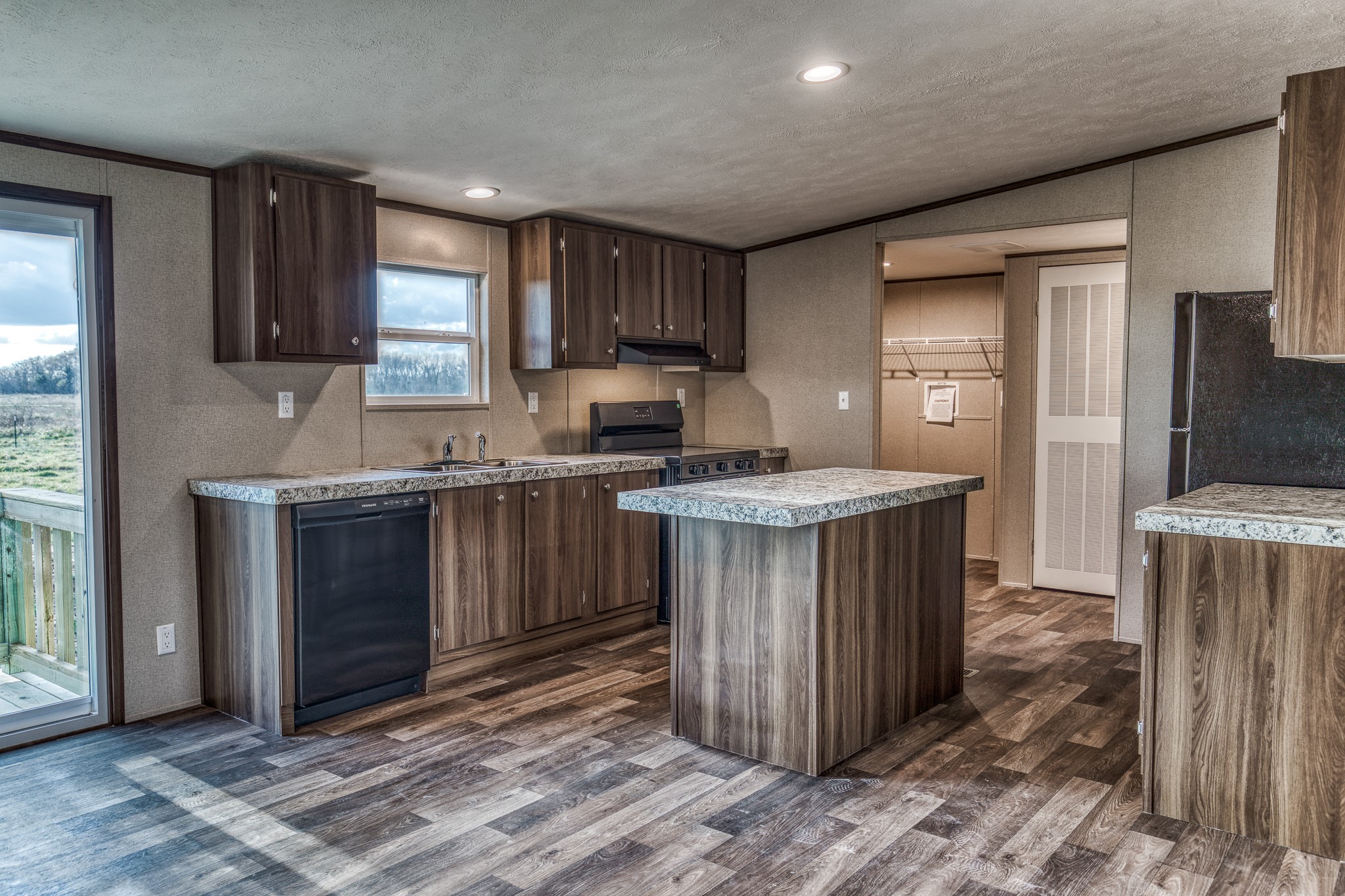 1001 Schmidt Road Waller, TX 77484 - Photo 6 of 28 a kitchen with kitchen island granite countertop a sink stove and cabinets