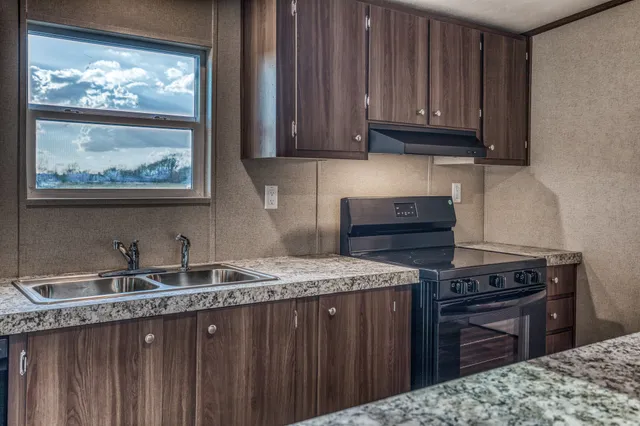 a kitchen with stainless steel appliances granite countertop a stove a sink and a microwave