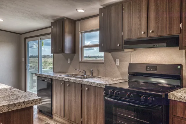 a kitchen with granite countertop a stove and a sink