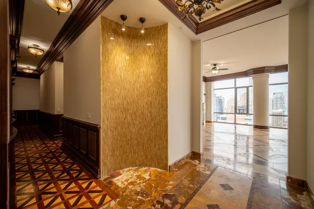 a view of hallway with a large window and chandelier