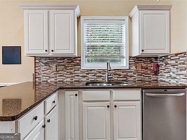 3624 White Sands Way Suwanee, GA 30024 - Photo 6 of 19 a kitchen with granite countertop white cabinets and sink