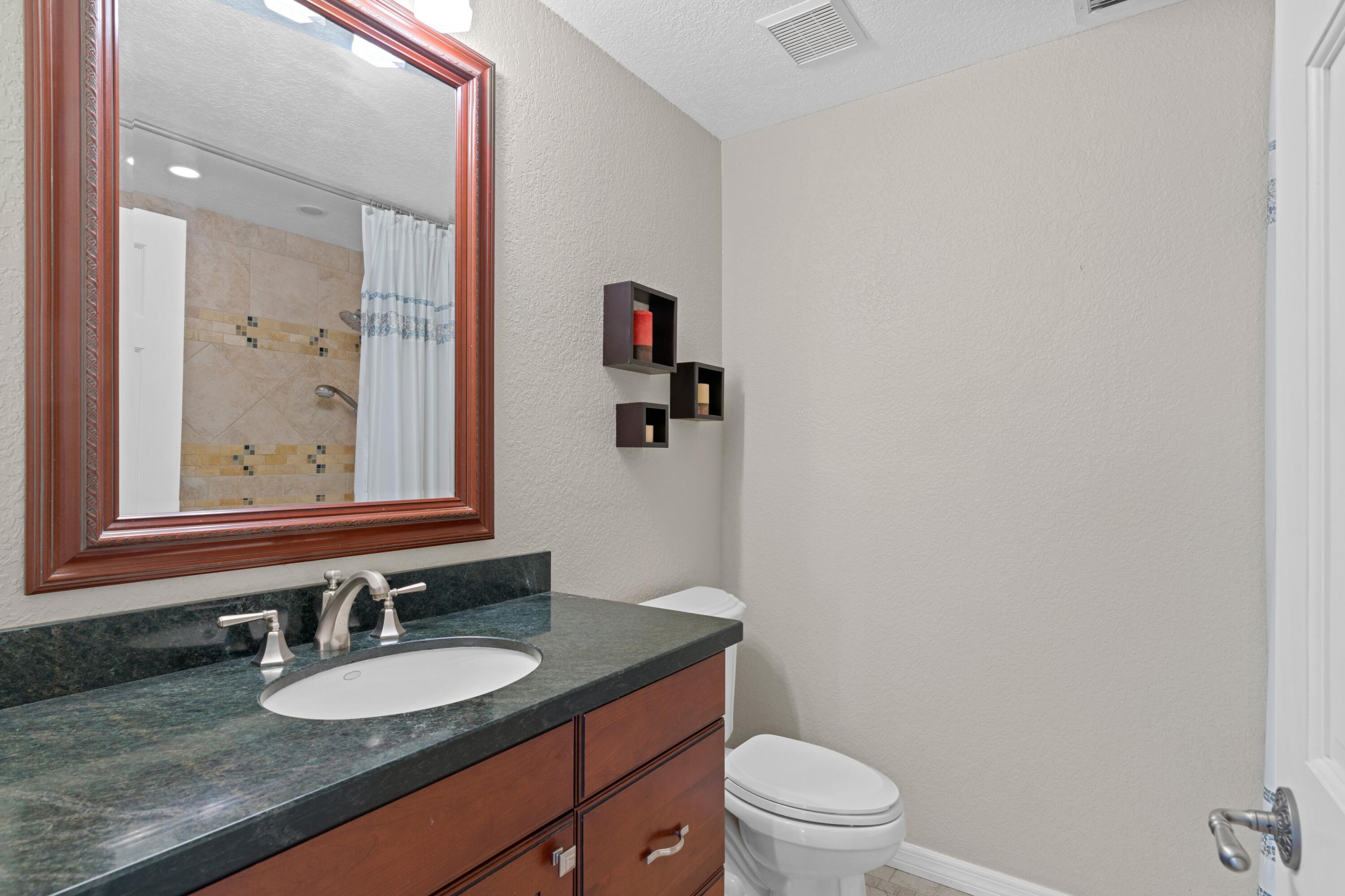 263 Northeast 24th Court Boca Raton, FL 33431 - Photo 11 of 29 a bathroom with a granite countertop sink mirror vanity and toilet
