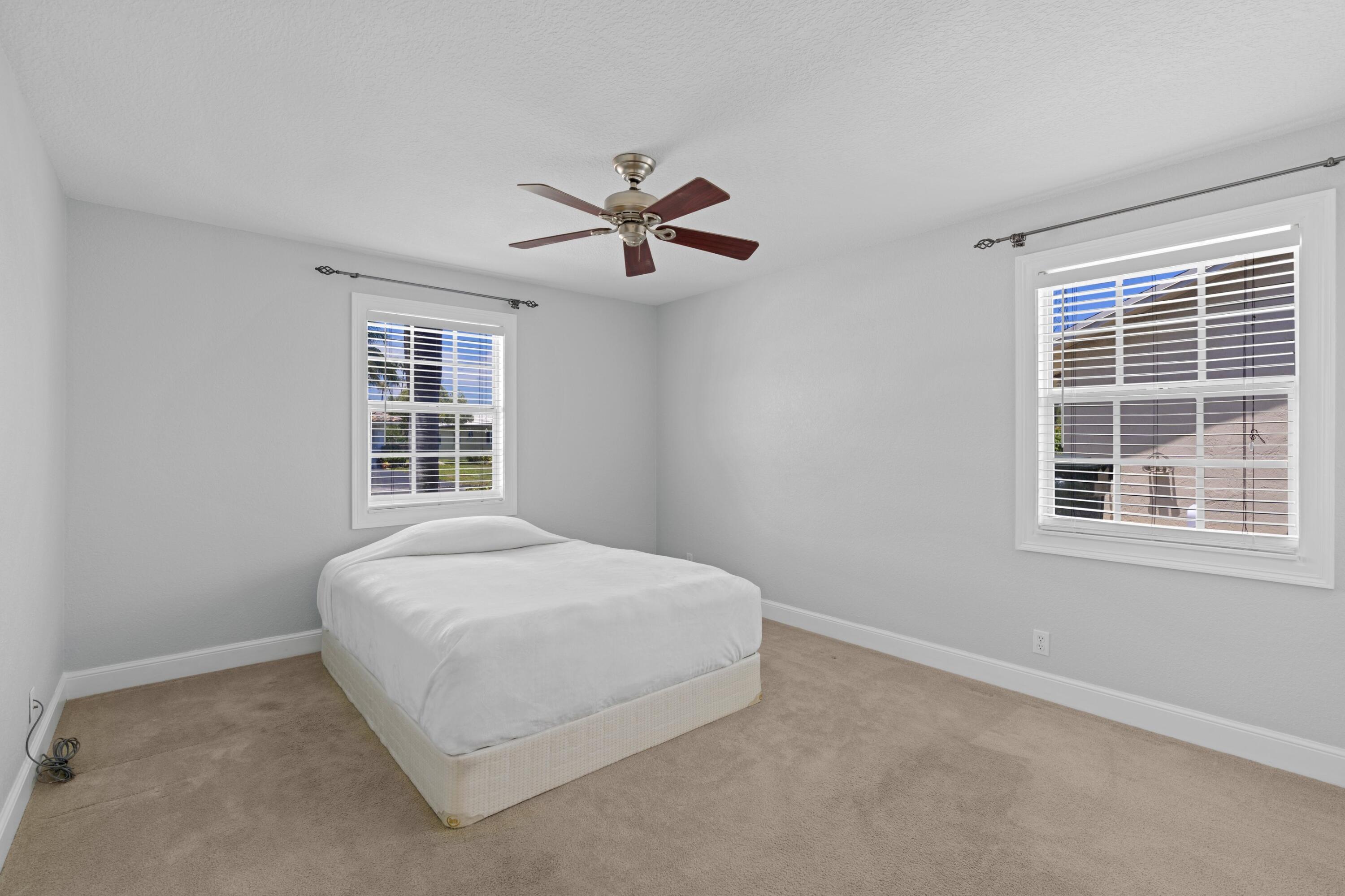 263 Northeast 24th Court Boca Raton, FL 33431 - Photo 13 of 29 a bedroom with a bed dresser and a window