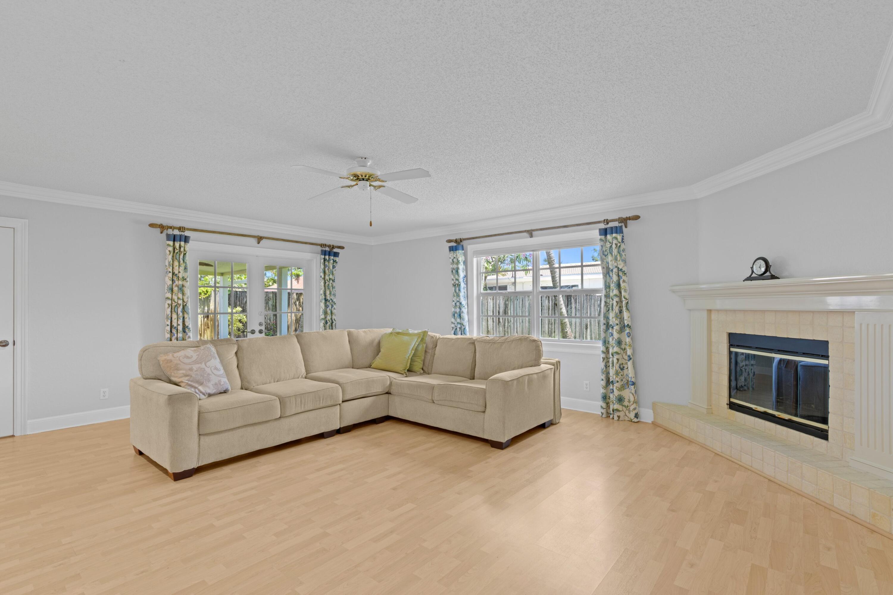 263 Northeast 24th Court Boca Raton, FL 33431 - Photo 4 of 29 a living room with furniture a fireplace and a flat screen tv