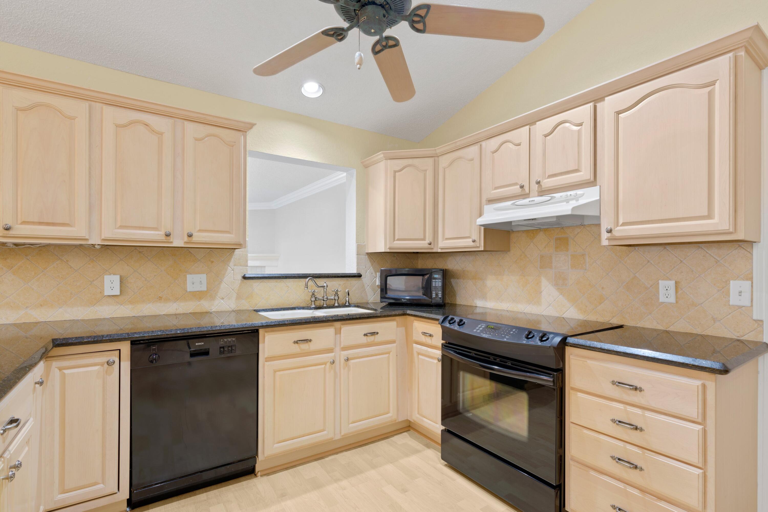 263 Northeast 24th Court Boca Raton, FL 33431 - Photo 5 of 29 a kitchen with granite countertop white cabinets white stainless steel appliances with a sink and dishwasher