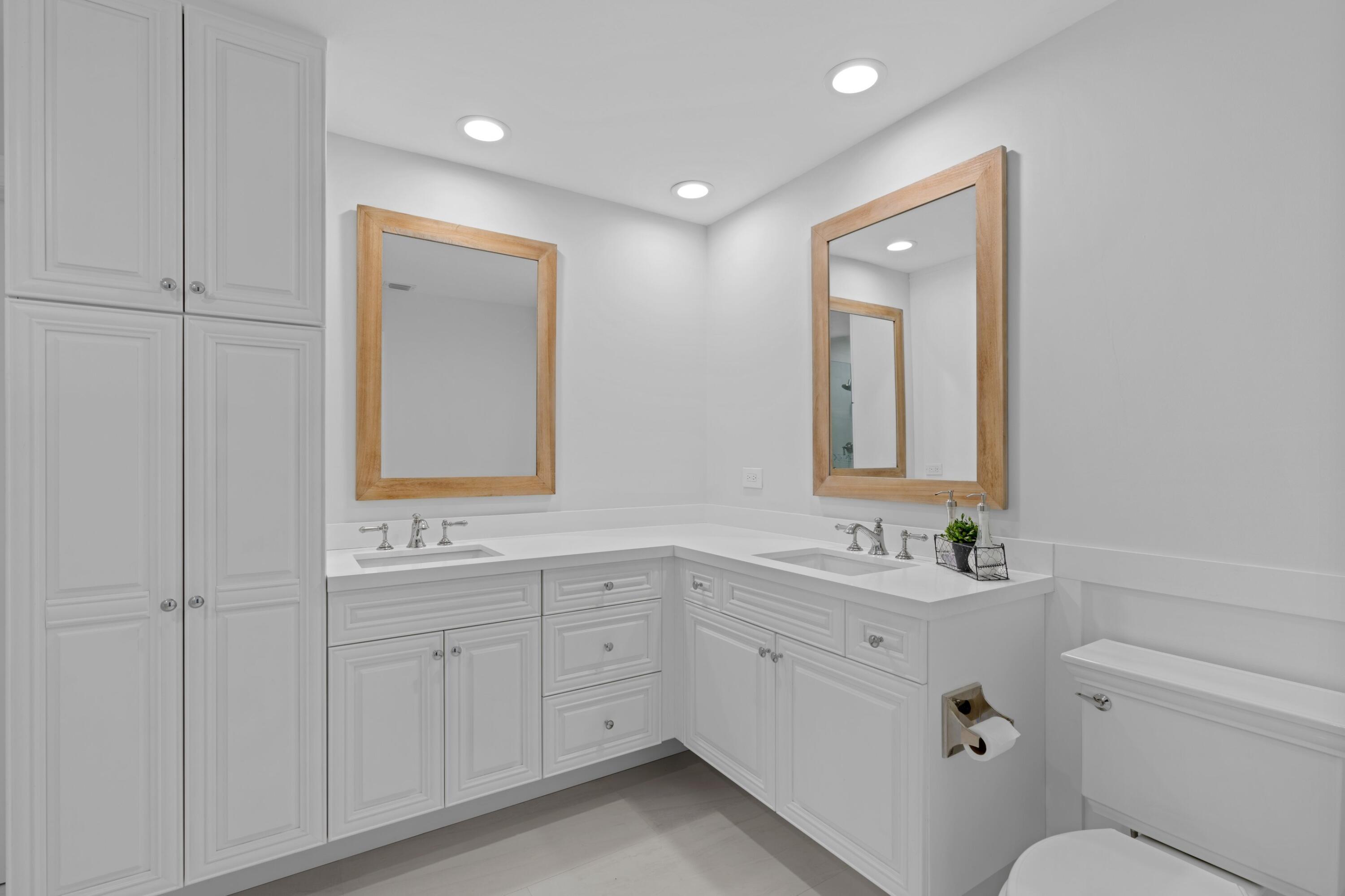 263 Northeast 24th Court Boca Raton, FL 33431 - Photo 8 of 29 a bathroom with a toilet a sink a mirror and vanity