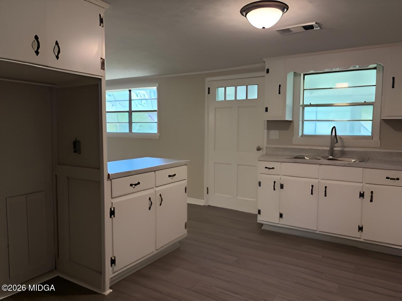 868 Mac Thompson Road Cochran, GA 31014 - Photo 11 of 31 a kitchen with granite countertop white cabinets and white appliances