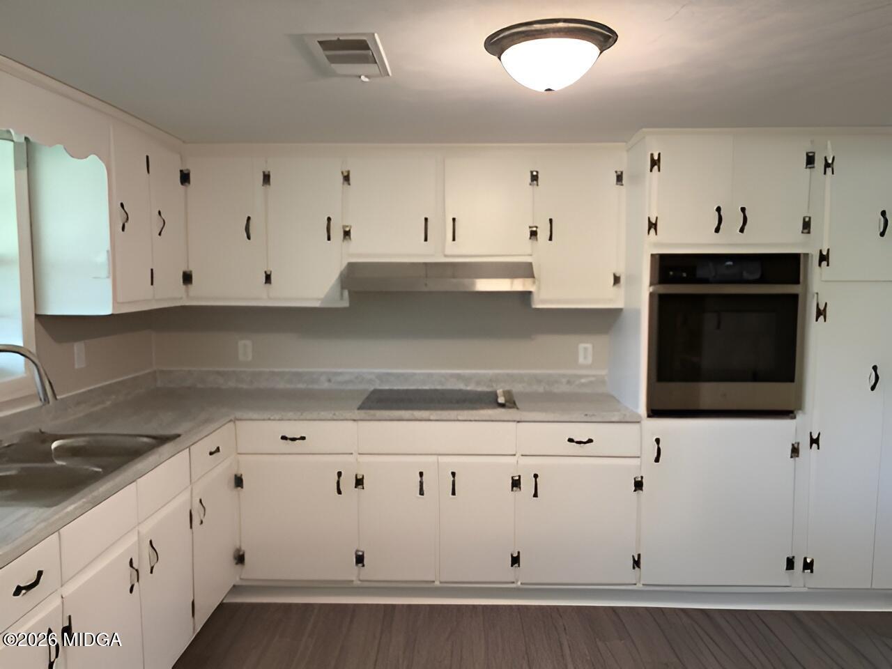 868 Mac Thompson Road Cochran, GA 31014 - Photo 14 of 31 a kitchen with stainless steel appliances granite countertop white cabinets sink and dishwasher
