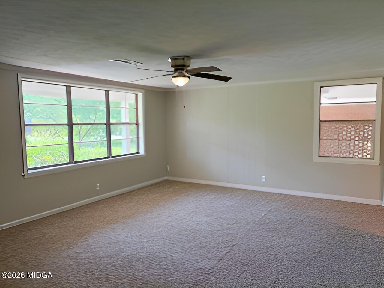 868 Mac Thompson Road Cochran, GA 31014 - Photo 4 of 31 an empty room with a window and a ceiling fan