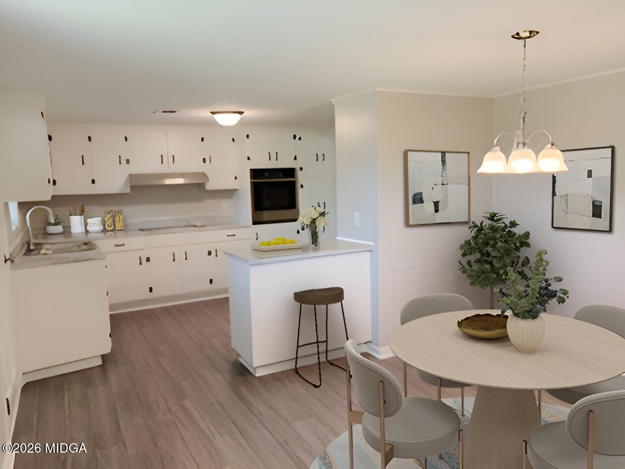 868 Mac Thompson Road Cochran, GA 31014 - Photo 5 of 31 a kitchen with stainless steel appliances a dining table chairs and a refrigerator