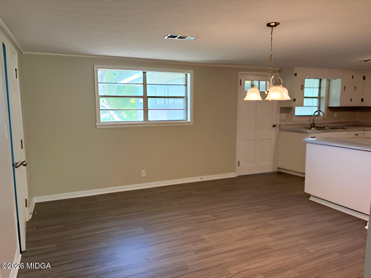 868 Mac Thompson Road Cochran, GA 31014 - Photo 7 of 31 an empty room with wooden floor and windows