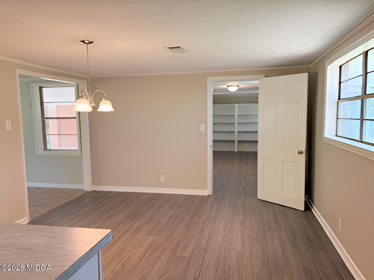 868 Mac Thompson Road Cochran, GA 31014 - Photo 8 of 31 an empty room with wooden floor and windows