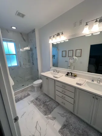 a bathroom with a double vanity sink mirror and shower