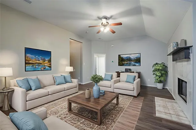 a living room with furniture a fireplace and a flat screen tv