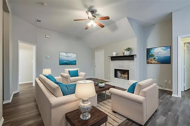 a living room with furniture a fireplace and a chandelier