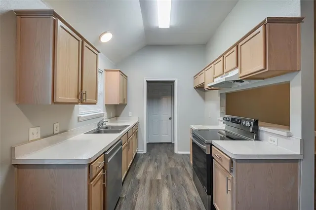 a kitchen with a sink stove and cabinets