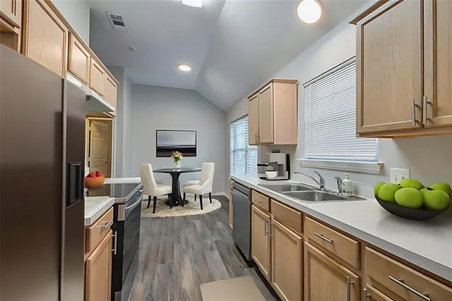 a kitchen with a sink cabinets and wooden floor
