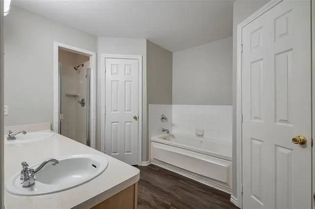 a bathroom with a tub sink and mirror