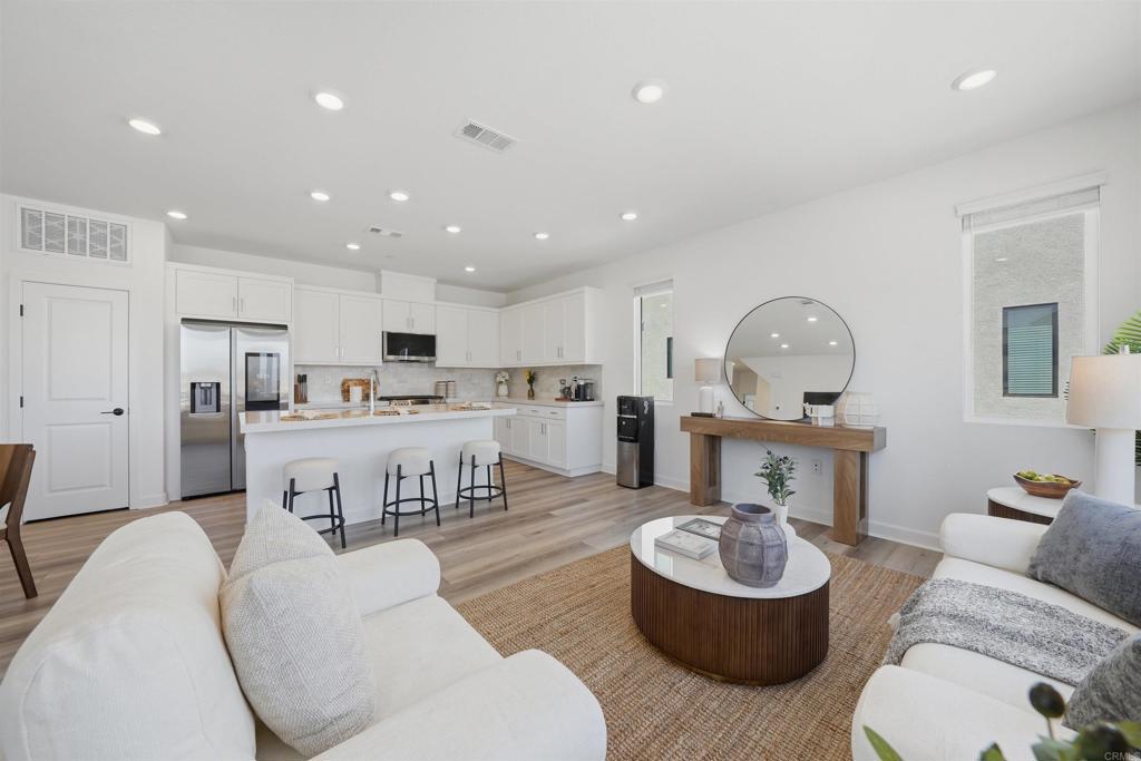 a living room with furniture and a view of kitchen
