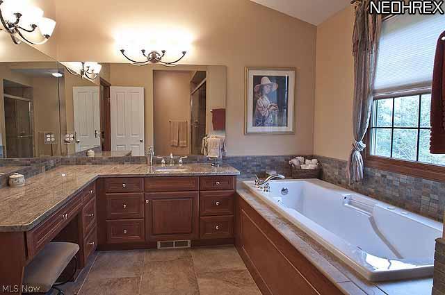 357 Longspur Road Highland Heights, OH 44143 - Photo 13 of 22 Gorgeous master glamour bath features 12 ft. high cathedral ceiling, granite countertop, cherry cabinets with tons of drawers, under-mount Kohler porcelain sink, built in sit-down make-up area, large jetted tub, mosaic tile backsplash and trim, and 18â?� porcelain tile on floors and to ceiling in fabulous large shower with oversized rain-style shower head